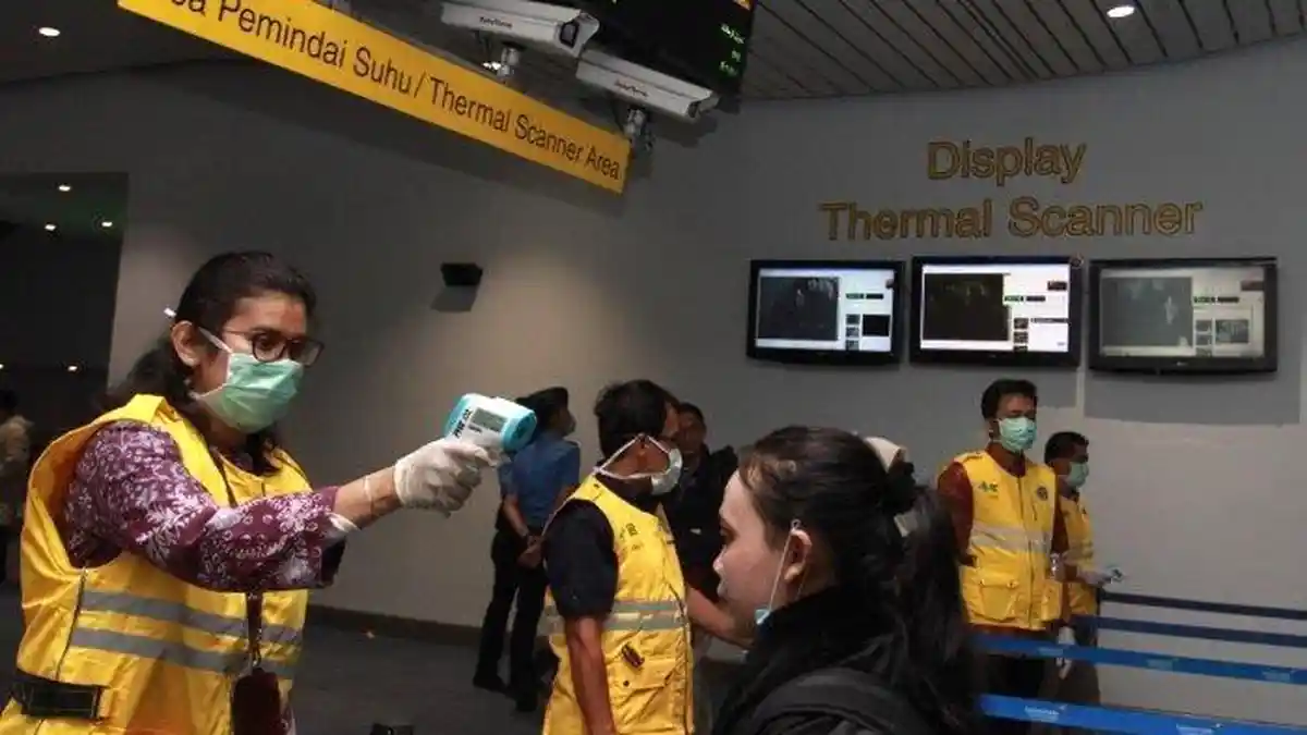 Petugas-thermo-gun-ke-penumpang-pesawat-kedatangan-internasional-bandara