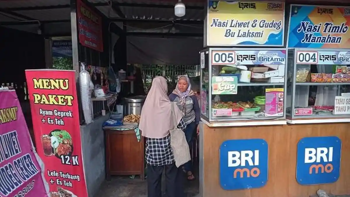 laksmi-memberikan-pesanan-kepada-pembeli-di-warung-nasi-liwet-mbak-laksmi