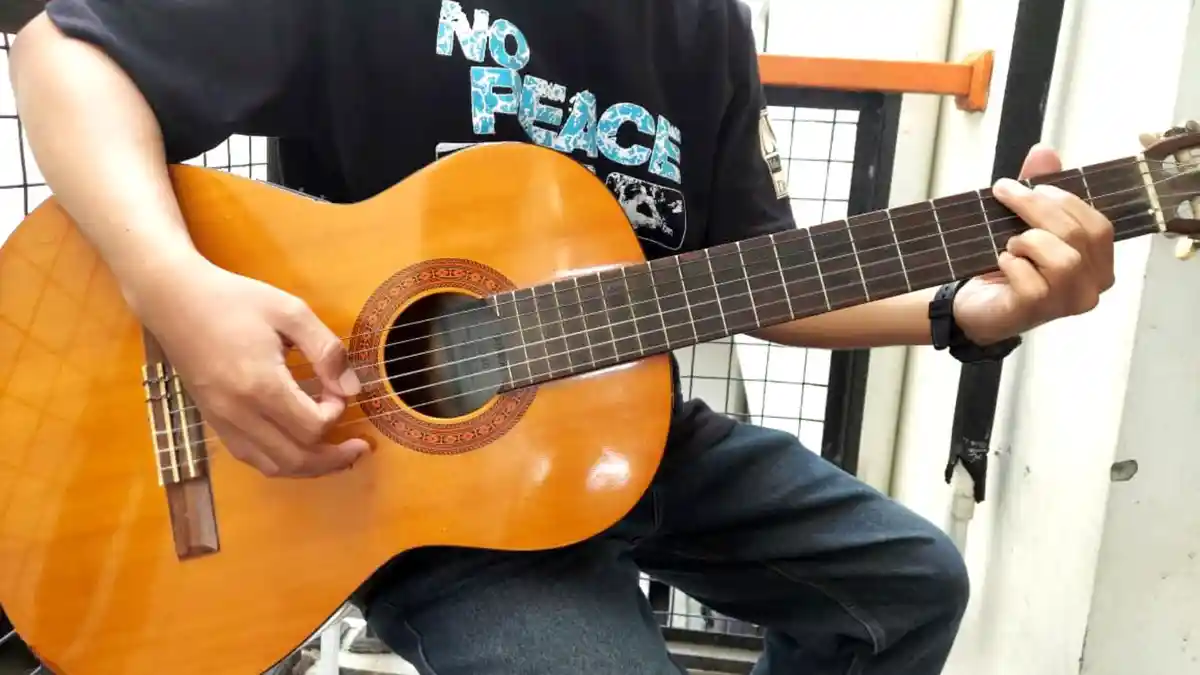 Potret-seseorang-sedang-bermain-gitar-dengan-kunci-chord-dasar-mudah-dimainkan